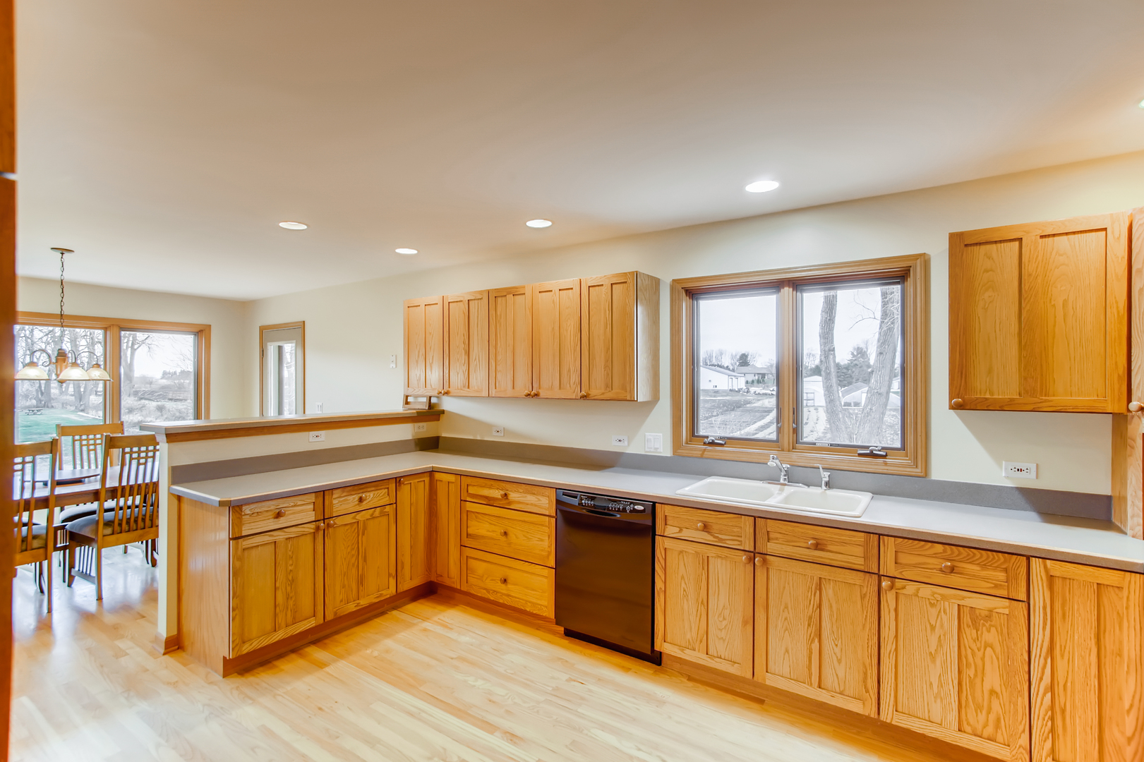 2N706 Howard Road Maple Park, IL 60151 - Photo 13 of 40 a large kitchen with granite countertop a sink and white cabinets with wooden floor