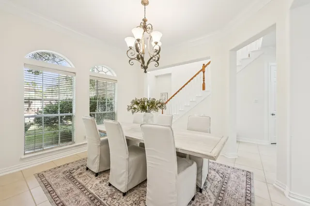 a dining room with wooden floor and a chandelier