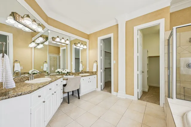 a spacious bathroom with a granite countertop sink and a mirror