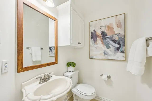 a bathroom with a toilet a sink and a mirror