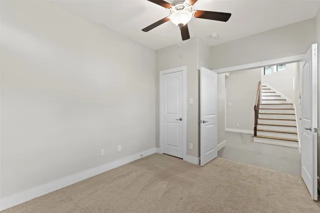 an empty room with closet and ceiling fan