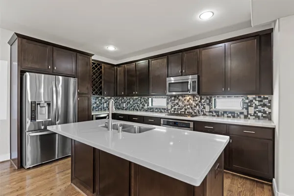 a kitchen with stainless steel appliances a sink and a refrigerator