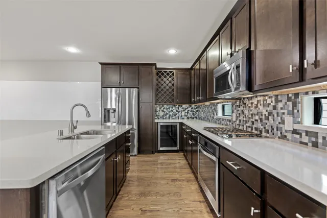 a kitchen with kitchen island granite countertop a sink stainless steel appliances and cabinets