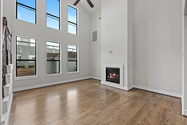 an empty room with wooden floor and a fireplace