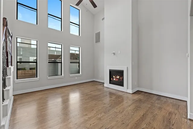 an empty room with wooden floor and a fireplace