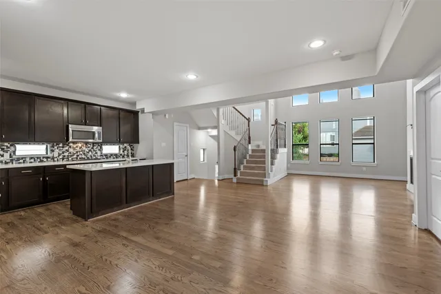 a large kitchen with a large counter top stainless steel appliances and cabinets