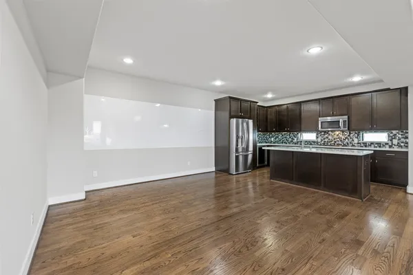 a kitchen with stainless steel appliances kitchen island granite countertop a refrigerator and a stove top oven