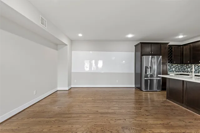 a view of kitchen with kitchen island a sink wooden floor and stainless steel appliances