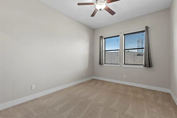 an empty room with closet and a ceiling fan