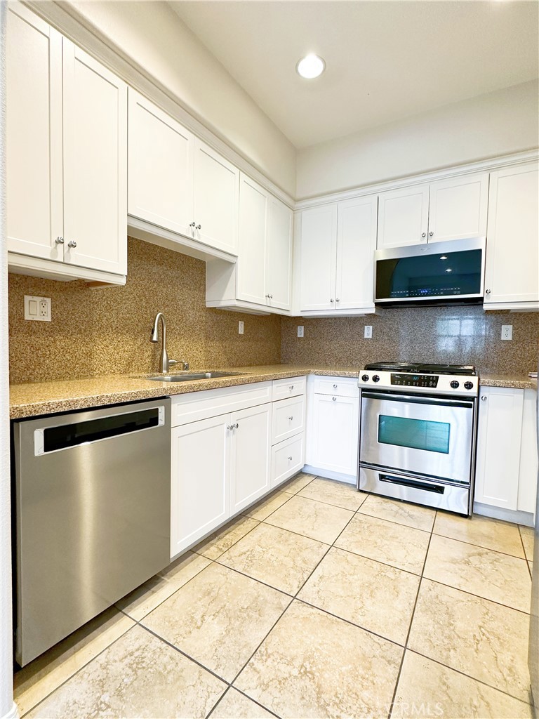 30 Pink Sage Irvine, CA 92620 - Photo 1 of 11 a kitchen with granite countertop a stove a sink and a microwave