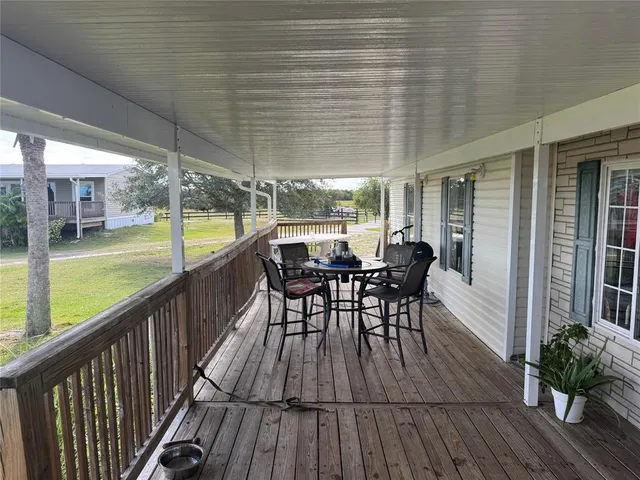 a view of a porch with furniture and wooden floor