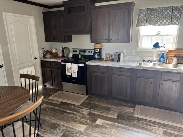 a kitchen with granite countertop wooden cabinets a sink and appliances