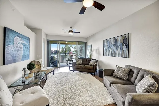 a living room with couches and kitchen view with wooden floor