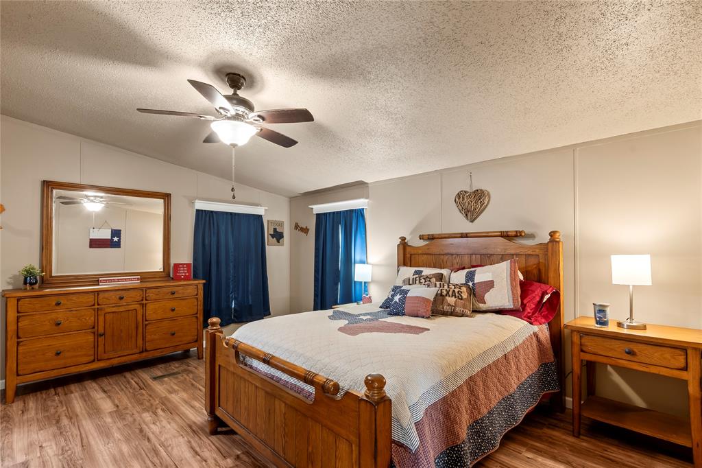 194 Indian Gap Road Mabank, TX 75156 - Photo 9 of 18 a bedroom with a large bed and a chandelier