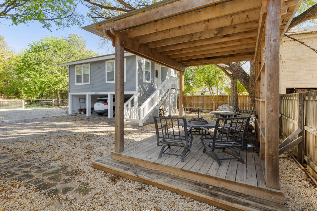 1223 1/2 South Austin Avenue Georgetown, TX 78626 - Photo 26 of 39 a view of a patio with dining table and chairs with wooden floor and fence