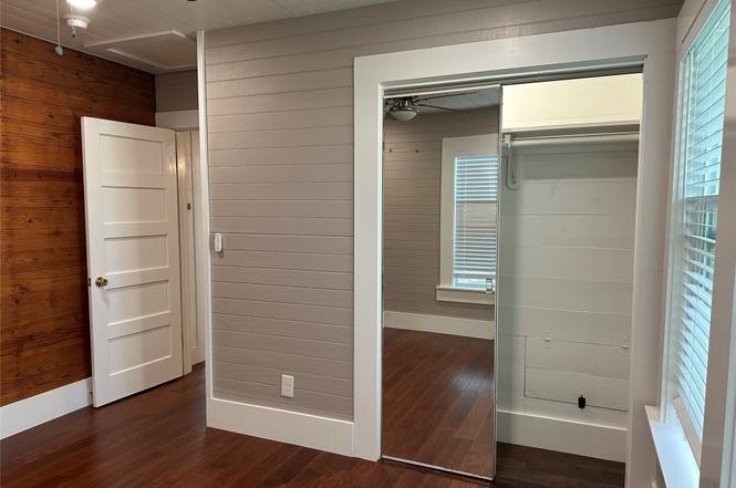 1223 1/2 South Austin Avenue Georgetown, TX 78626 - Photo 37 of 39 an empty room with wooden floor mirror and windows