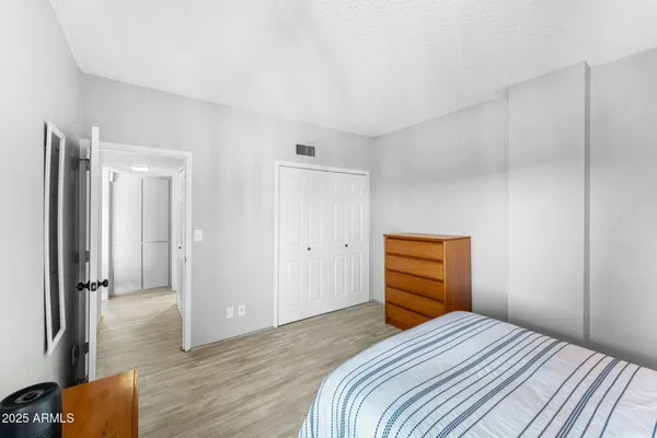 a bedroom with a bed and wooden floor