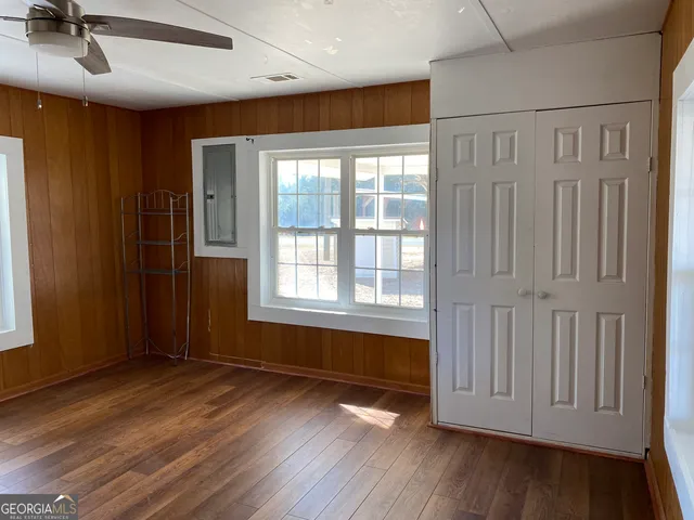 an empty room with wooden floor and windows
