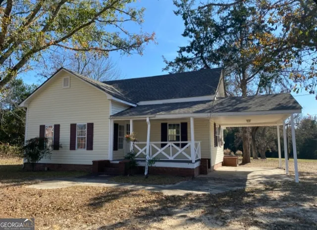a view of a house with a patio and a yard