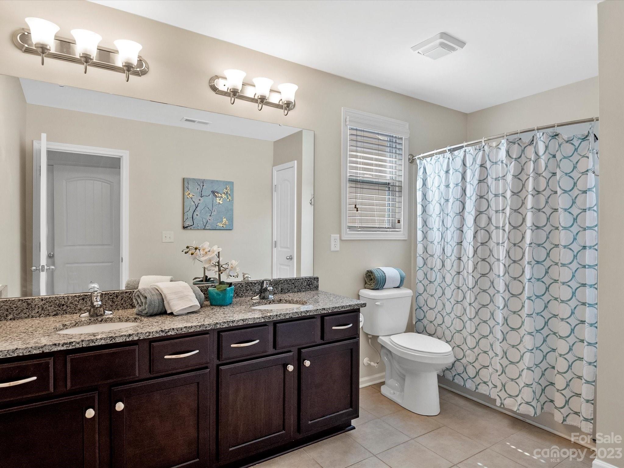 78005 Rillstone Drive Lancaster, SC 29720 - Photo 28 of 41 a bathroom with a double vanity sink toilet and a mirror