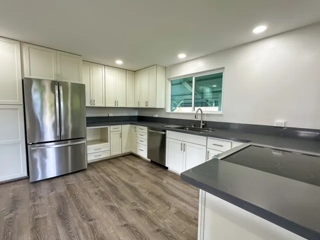a kitchen with granite countertop a refrigerator and a sink