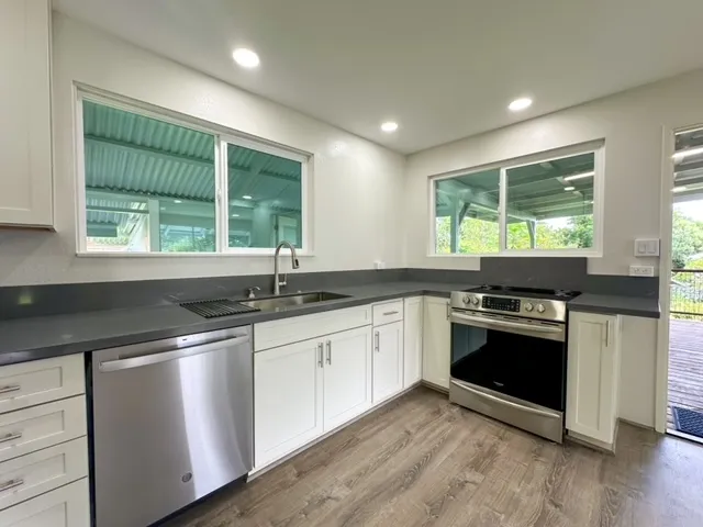 a kitchen with granite countertop a sink and stainless steel appliances