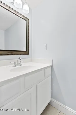 a kitchen with granite countertop a sink and a white cabinets