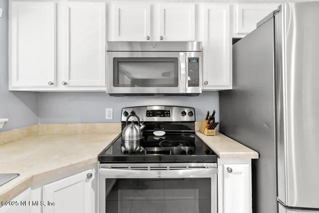 a kitchen with appliances cabinets and a table