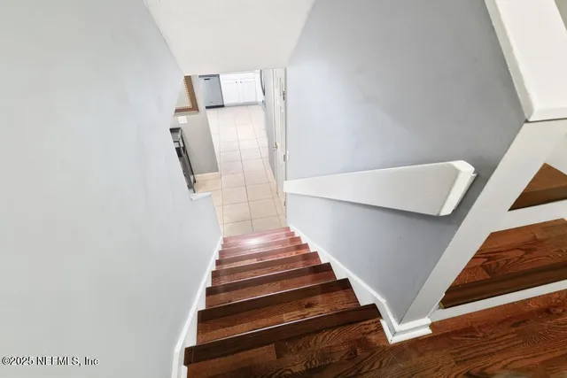 a view of a room with wooden floor and a ceiling fan