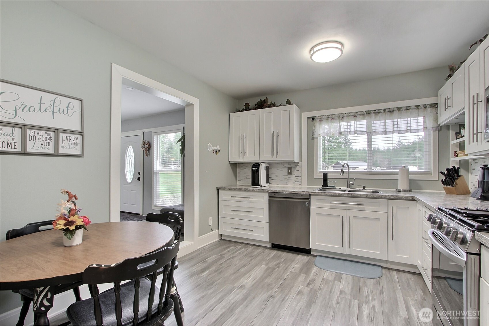 149 Barton Road Rochester, WA 98579 - Photo 23 of 36 a kitchen with white cabinets stove and kitchen island