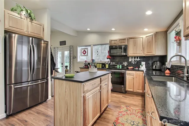 a kitchen with stainless steel appliances granite countertop a refrigerator and a stove top oven