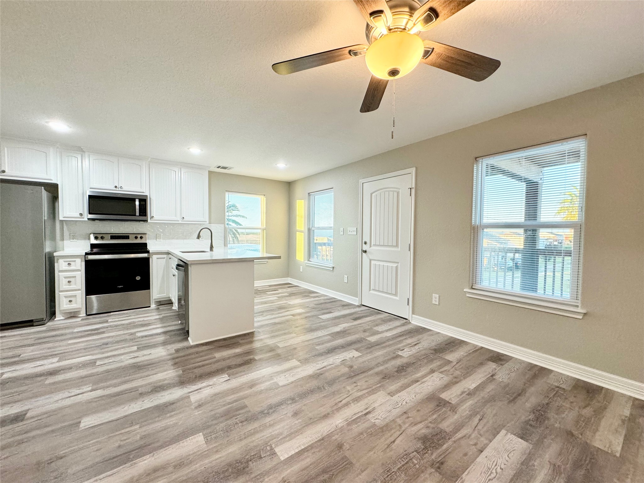511 Caisson Street Surfside Beach, TX 77541 - Photo 9 of 33 a view of a kitchen with a stove cabinets a ceiling fan and wooden floor
