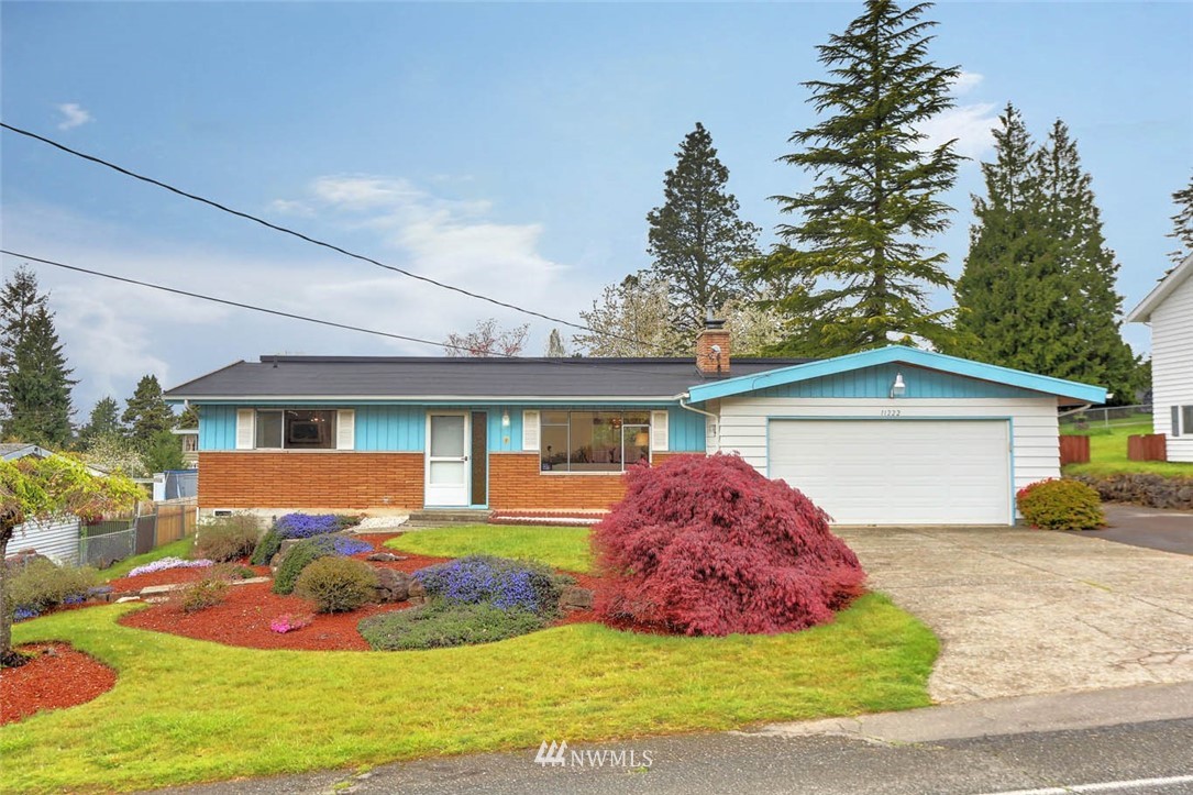 11222 Southeast 182nd Street Renton, WA 98055 - Photo 1 of 24 a front view of a house with a yard and garage