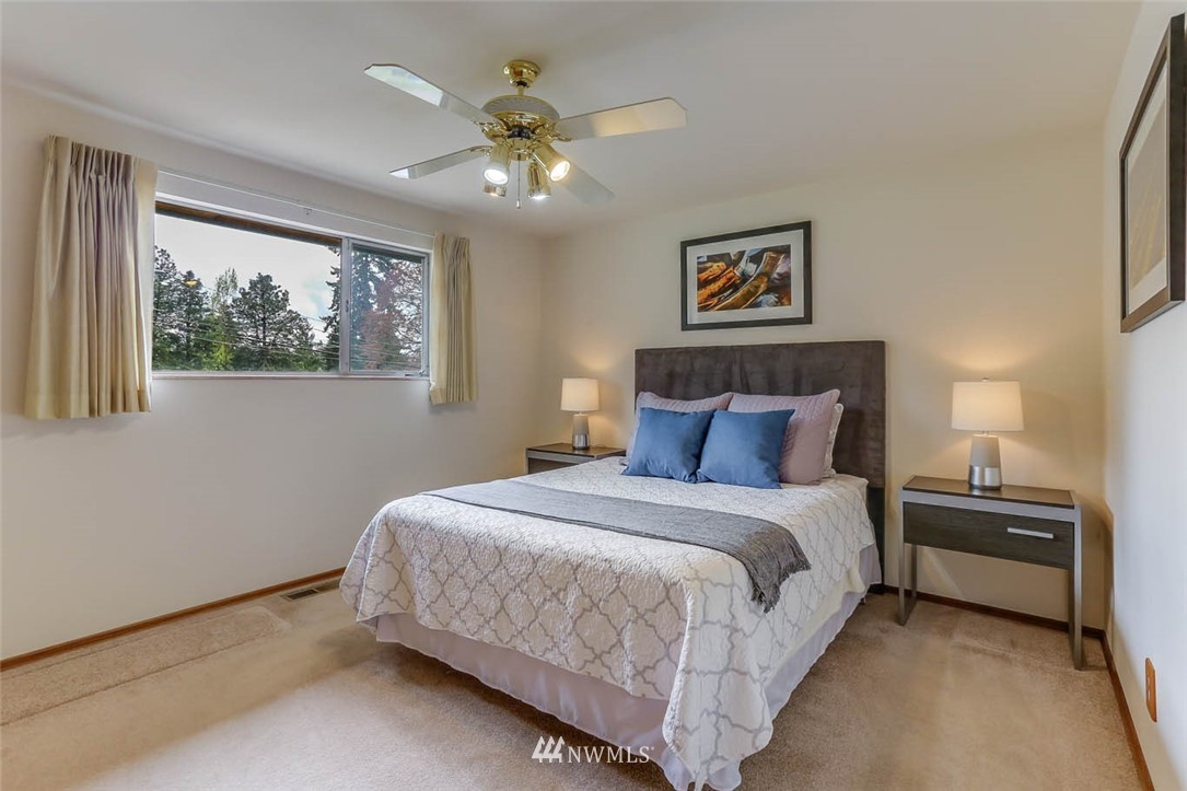 11222 Southeast 182nd Street Renton, WA 98055 - Photo 14 of 24 a bedroom with a bed and a chandelier