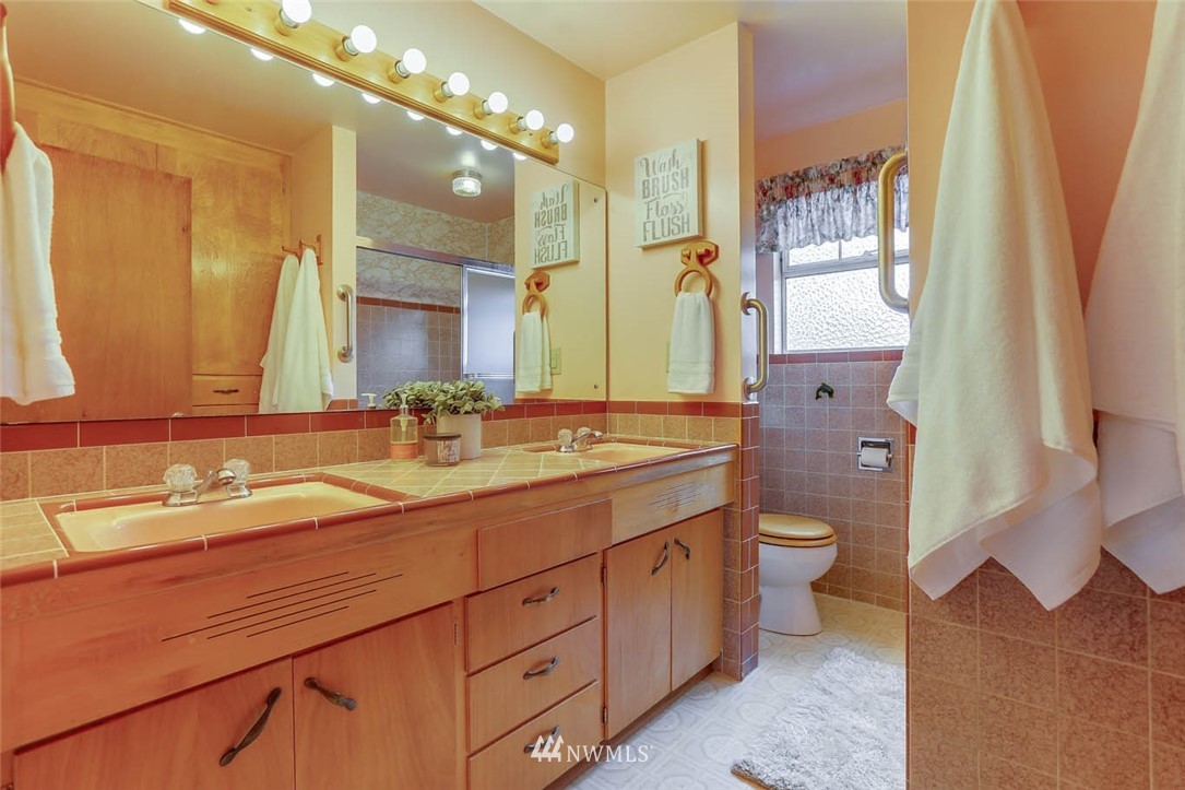 11222 Southeast 182nd Street Renton, WA 98055 - Photo 17 of 24 a bathroom with a double vanity sink a mirror and a toilet