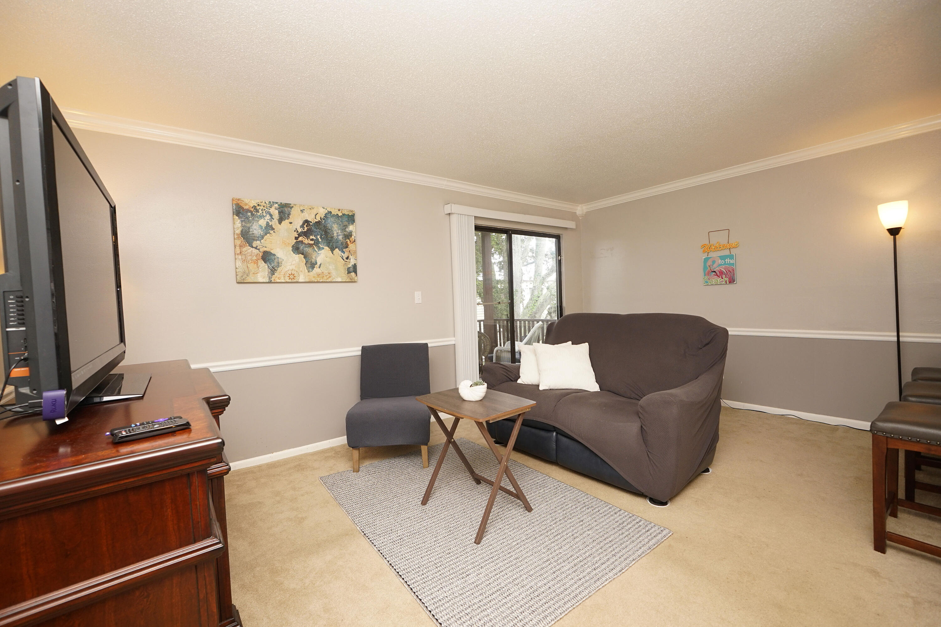 308 Miracle Strip Parkway Southwest, Unit 7D Fort Walton Beach, FL 32548 - Photo 16 of 34 a living room with furniture a flat screen tv and a window
