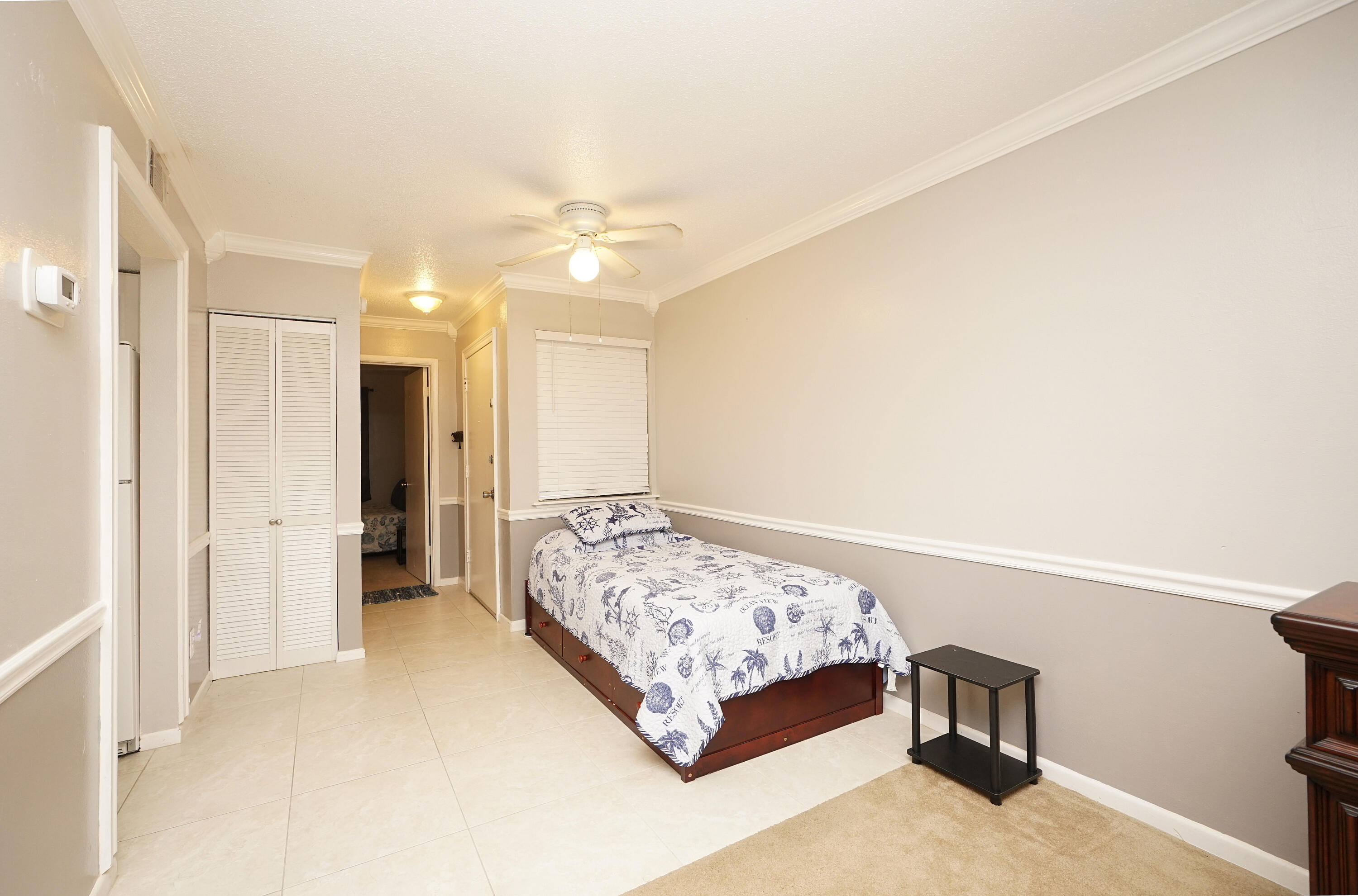 308 Miracle Strip Parkway Southwest, Unit 7D Fort Walton Beach, FL 32548 - Photo 20 of 34 a bedroom with a bed and a chandelier