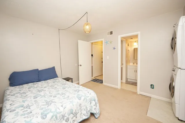 a bedroom with a bed and a refrigerator