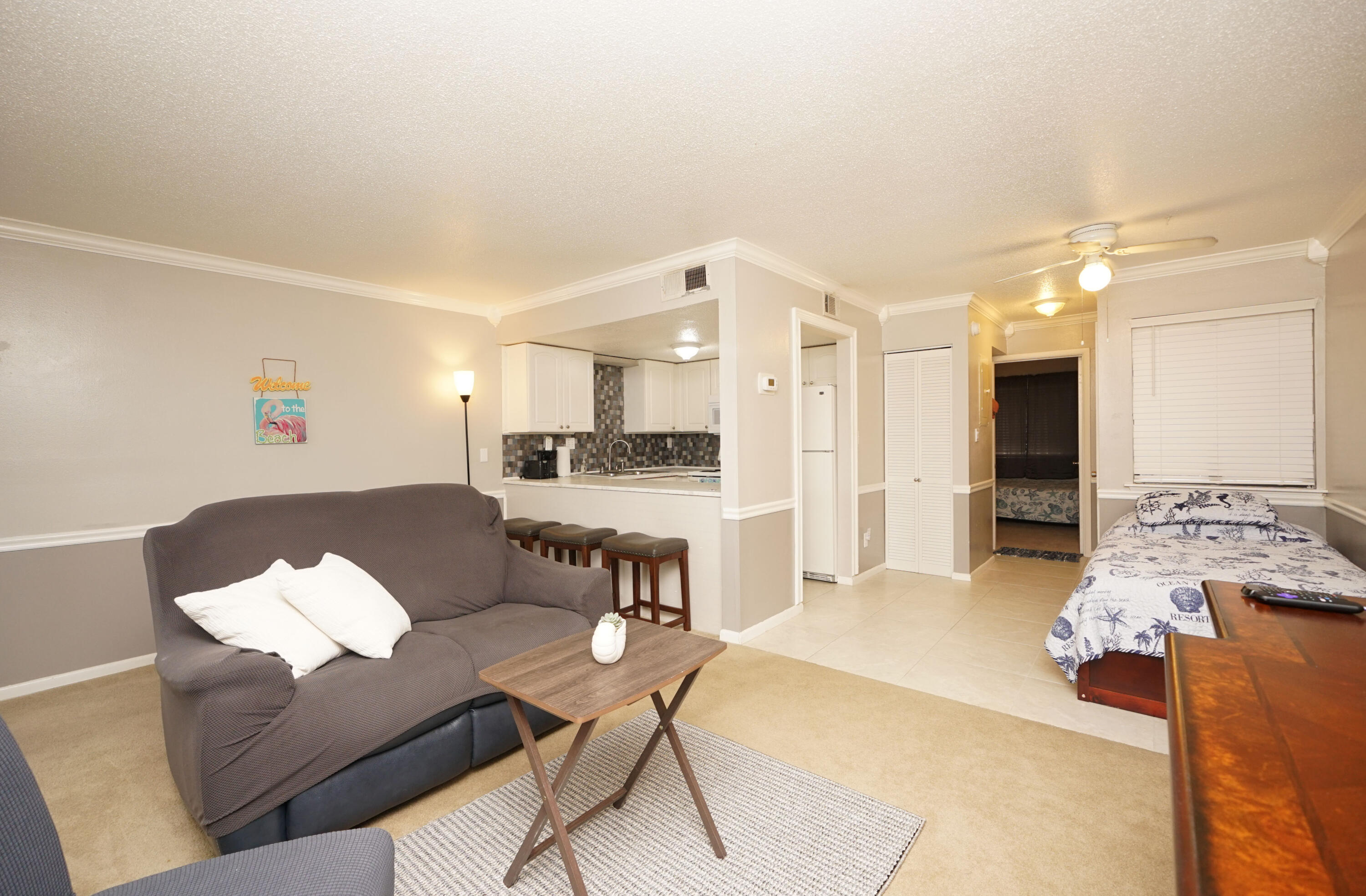 308 Miracle Strip Parkway Southwest, Unit 7D Fort Walton Beach, FL 32548 - Photo 8 of 34 a living room with furniture and a dining table with kitchen view