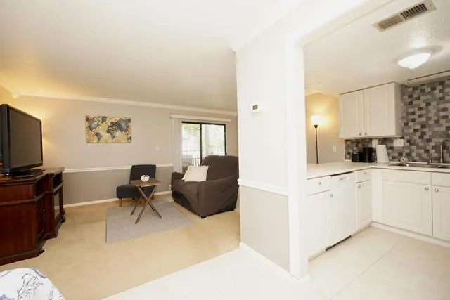 a kitchen with furniture a flat screen tv and a refrigerator