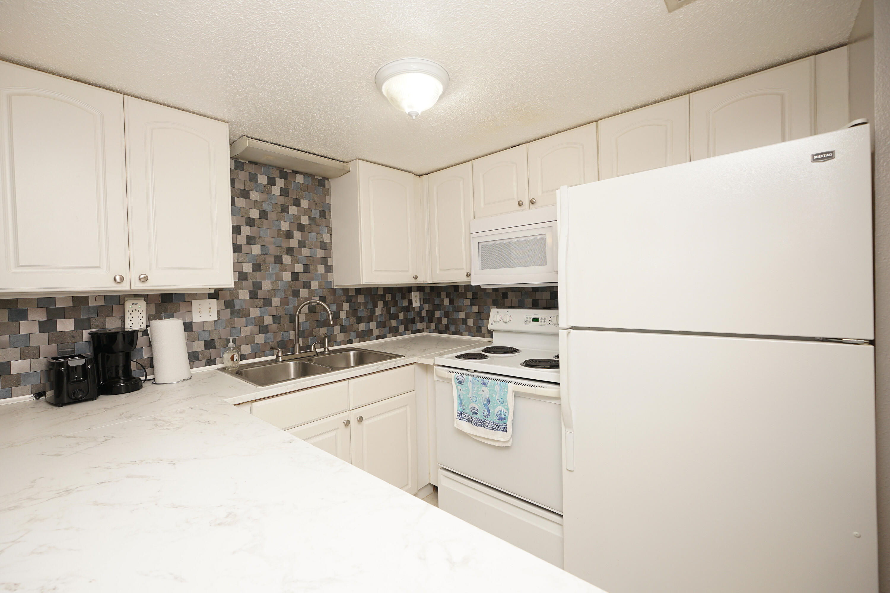 308 Miracle Strip Parkway Southwest, Unit 7D Fort Walton Beach, FL 32548 - Photo 10 of 34 a white refrigerator freezer sitting in a kitchen