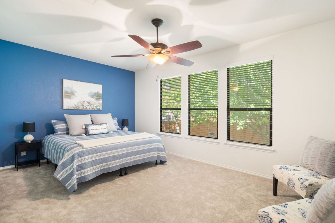 366 Matthews Lane Kyle, TX 78640 - Photo 14 of 25 a bedroom with a large bed and a large window