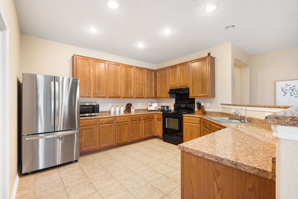 366 Matthews Lane Kyle, TX 78640 - Photo 8 of 25 a kitchen with a refrigerator sink and cabinets
