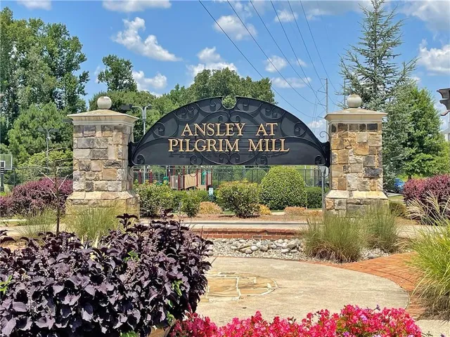 a sign board with a house in the background