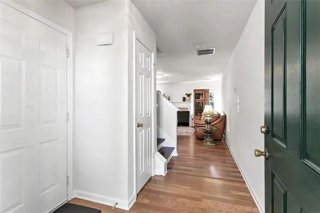 a hallway with white doors wooden floor and chair