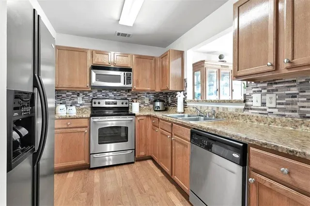 a kitchen with stainless steel appliances granite countertop a stove sink and cabinets
