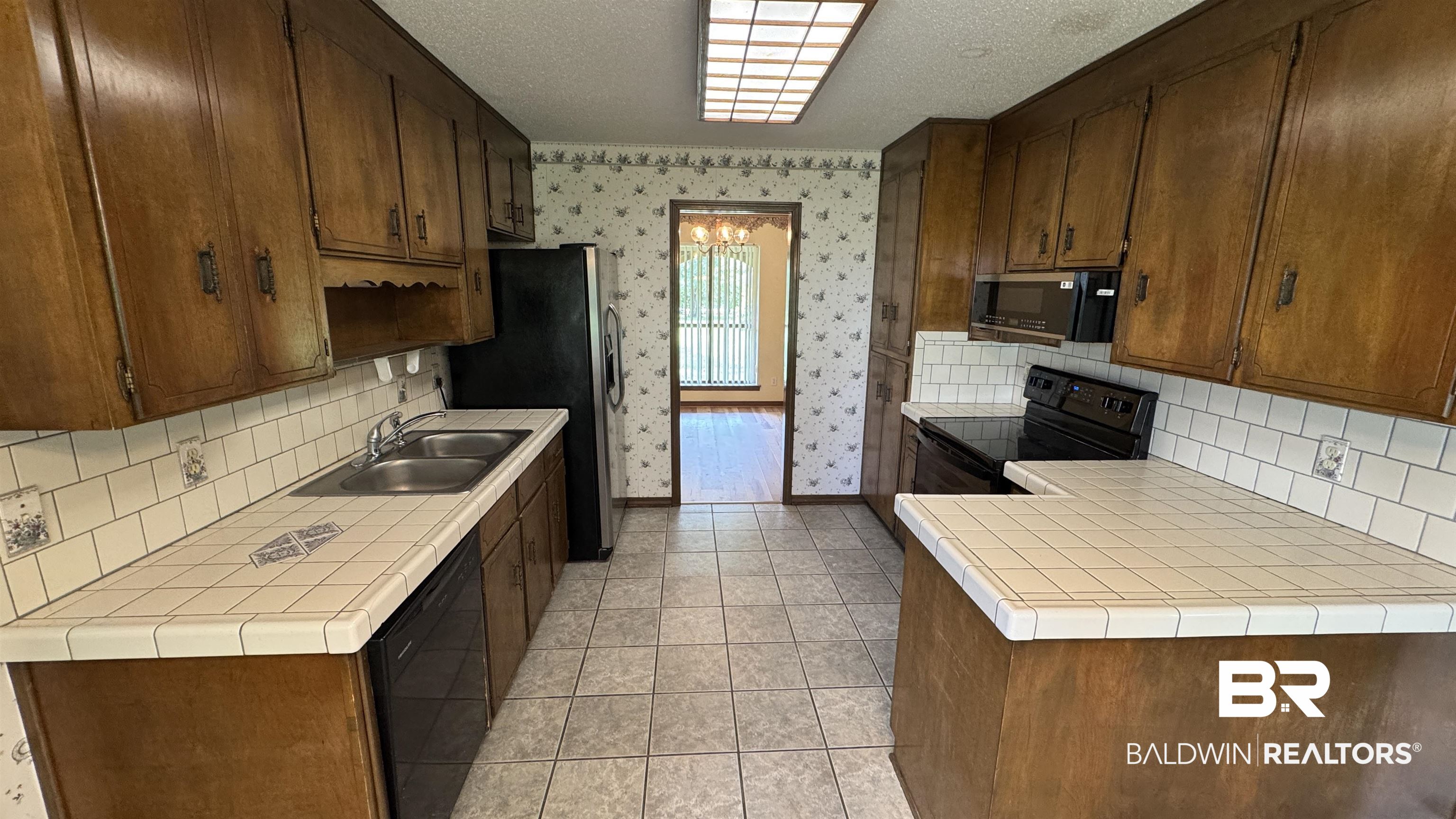 33370 Highway 98 Lillian, AL 36549 - Photo 24 of 58 Kitchen featuring wood cabinetry, white tile countertops, subway tile backsplash, and a double basin stainless steel sink
