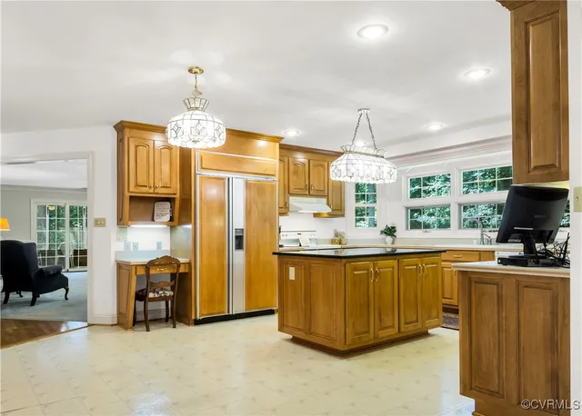 a kitchen with cabinets a center island and appliances