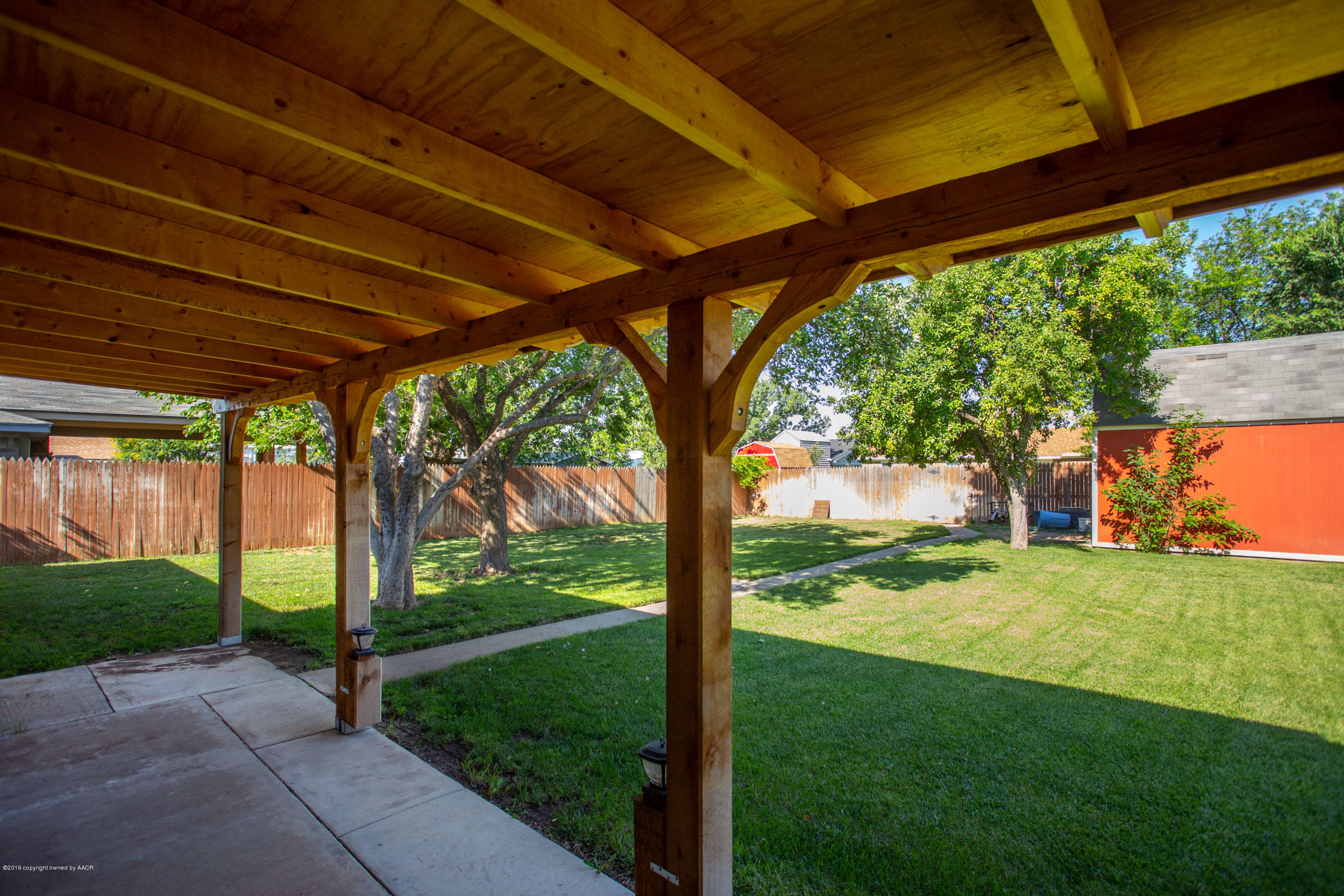 8110 Santa Fe Trail Amarillo, TX 79110 - Photo 20 of 25 a view of a backyard with table and chairs under a large umbrella
