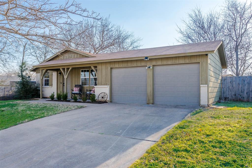 a front view of house with yard and trees in the background